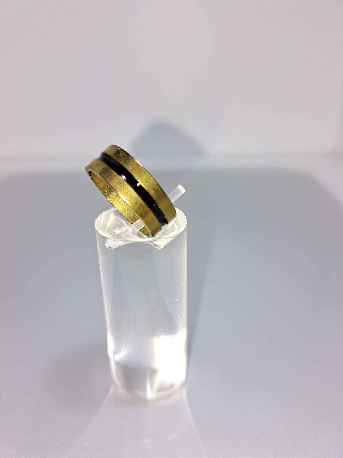 Gold stainless steel unisex ring with a black rounded channel around the band. Perfect costume jewellery.